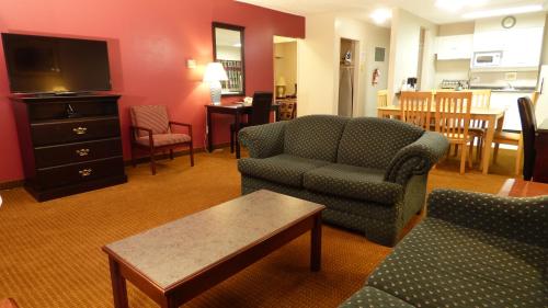 a living room with a couch and a chair and a tv at Port Augusta Inn in Comox