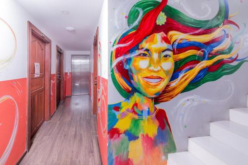 a mural of a woman on a wall in a hallway at Ostello Bello Mandalay in Mandalay