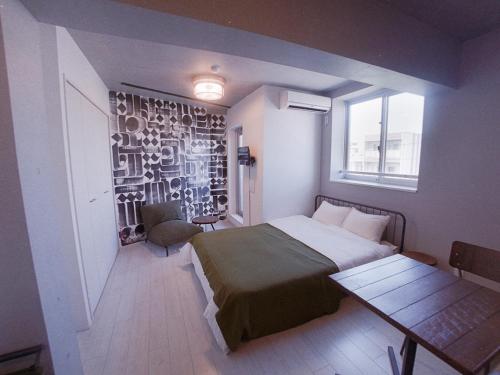 a bedroom with a bed and a table and a window at AOCA KAMINOGE 401 in Tokyo