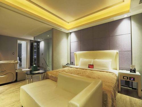 1 dormitorio con 1 cama, 1 sofá y 1 silla en Royal Group Motel Buo Ai Branch, en Kaohsiung