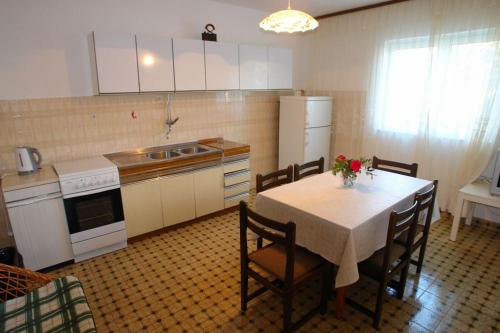 a kitchen with a table and chairs and a kitchen with a sink at Apartments Darinka in Sevid