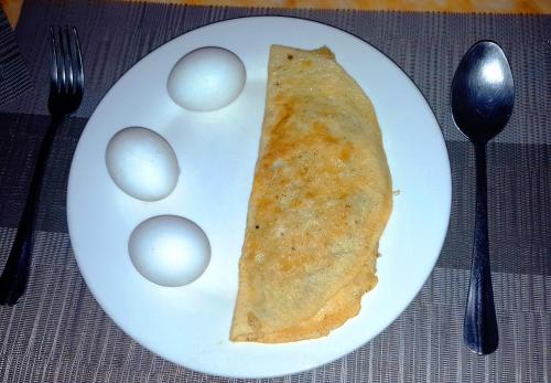 a white plate with a piece of food and eggs at MJ Room Rental in Panglao