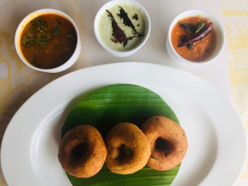 a plate of food with donuts on a plate at Abad Turtle Beach in Mararikulam