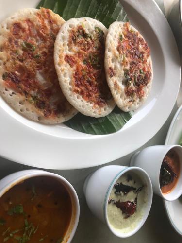 two plates of food with soup and a plate of bread at Abad Brookside Wayanad in Vythiri