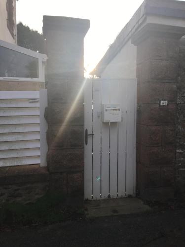 a white door on the side of a house at Studio Vue Mer - Idéal Voyageur Solo, à Vélo, à Pied in Perros-Guirec