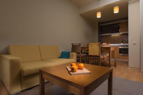 a living room with a couch and a table at Effect Malina Residence Hotel in Pamporovo