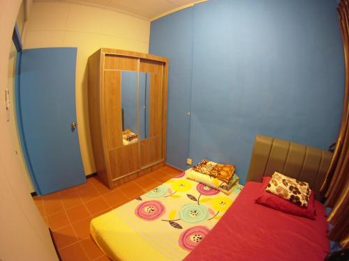 a room with a bed and a table and a mirror at D'Gaia Homestay Sandakan in Sandakan