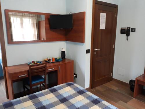a bedroom with a bed and a desk and a television at B&B IL GHIRO in Roccaraso