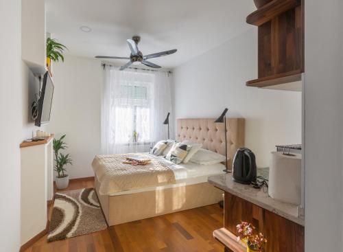 une chambre avec un lit et un ventilateur de plafond dans l'établissement Palace Apartments by ZGrent, à Zagreb