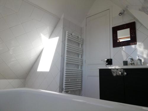 La salle de bains est pourvue d'une baignoire et d'un mur lumineux. dans l'établissement Bienvenue à la maison, à Le Theil-en-Auge