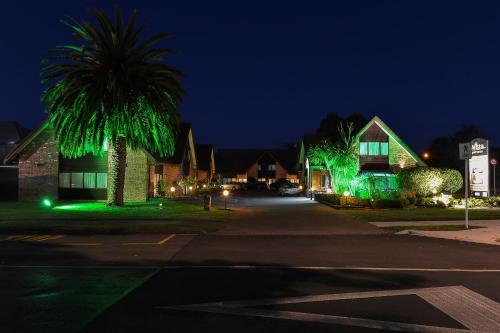 a street with houses decorated with green lights at night at Arista of Rotorua in Rotorua