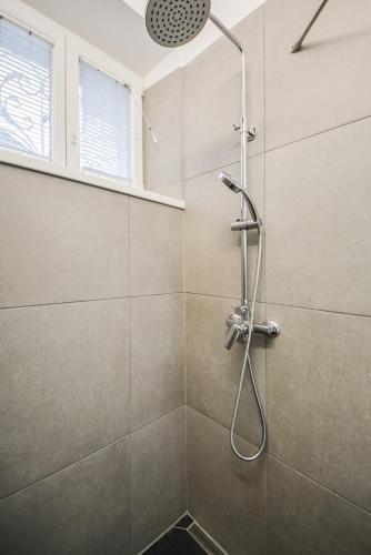 a shower with a shower head in a bathroom at Kavon Apartments in Ljubljana