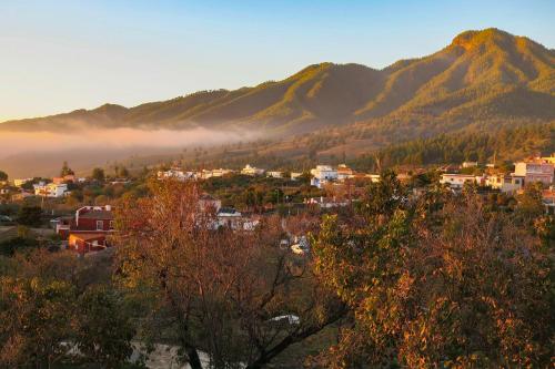 a small town in the mountains with fog in the valley at Finca Cosmos in El Paso