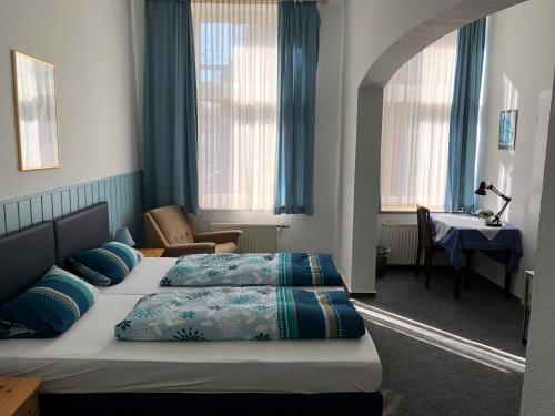 ein Hotelzimmer mit 2 Betten und einem Schreibtisch in der Unterkunft Hotel Westfälischer Hof in Hattingen