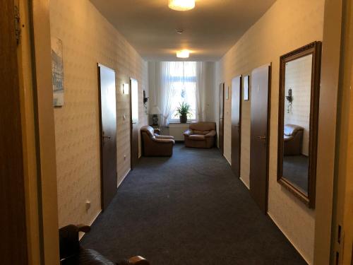 a hallway with chairs and a living room in a building at Hotel Westfälischer Hof in Hattingen