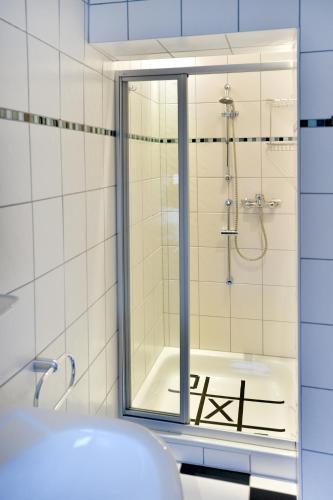 a bathroom with a shower and a tub and a sink at Fewo Waldesruh in Kaisersesch
