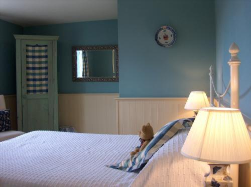 a bedroom with a bed with a lamp and a blue wall at The Hunters Rest Inn in Clutton