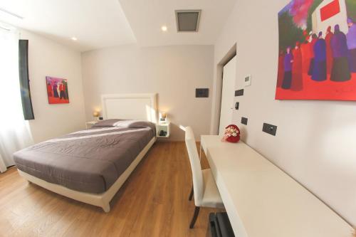 a bedroom with a bed and a desk in it at RESIDENZE CASSOLI - Lamezia Centro in Lamezia Terme