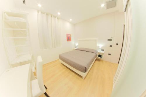a bedroom with a bed in a white room at RESIDENZE CASSOLI - Lamezia Centro in Lamezia Terme