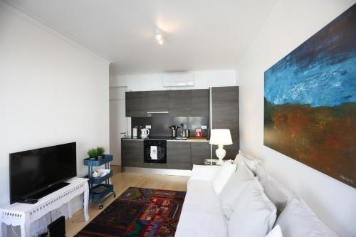 a living room with a white couch and a flat screen tv at Central Lisbon Luxury Apartment in Lisbon