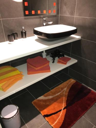 a bathroom with a sink and a shelf with towels at Residenza San Remy in Unterkulm