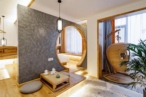 a living room with a round mirror and a table at Zhangjiajie Su Xin Resort Near Tianmen Shan & Hehua airport-Free pick up in Zhangjiajie