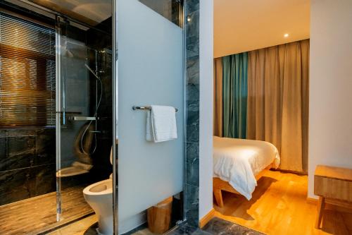a bathroom with a shower and a toilet and a bed at Zhangjiajie Su Xin Resort Near Tianmen Shan & Hehua airport-Free pick up in Zhangjiajie