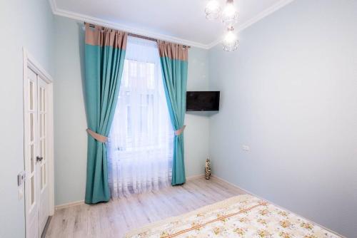 リヴィウにあるKulisha Cosy Apartmentのベッドルーム1室(ベッド1台、青いカーテン付きの窓付)