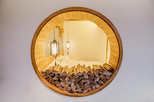 a circular mirror with wood logs around it at Su Xin Resort Inn in Zhangjiajie