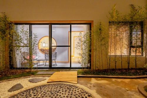 a room with a large glass door and a table at Zhangjiajie Su Xin Resort Near Tianmen Shan & Hehua airport-Free pick up in Zhangjiajie