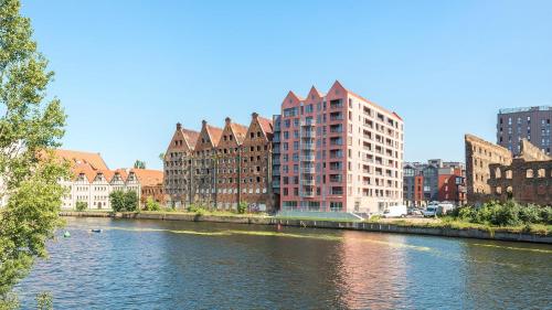 rzeka w mieście z wysokimi budynkami w obiekcie WaterLane Island Hostel&Apartments w Gdańsku