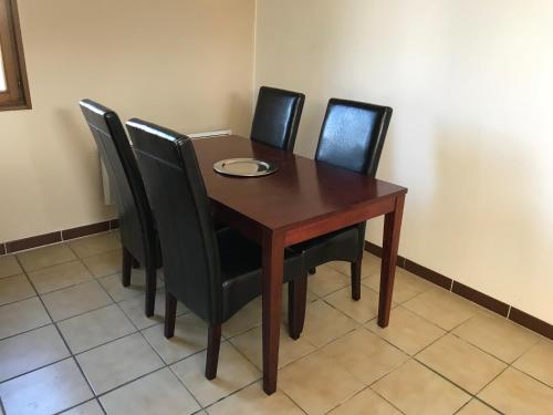 - une table en bois avec des chaises noires et une plaque de cuisson dans l'établissement Maison 2Ch - 4 pers en Picardie parking gratuit - by La Source d'OrFée, à Courcelette