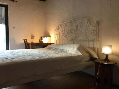 1 dormitorio con 1 cama blanca y 2 lámparas en The Refuge, en Bachevo