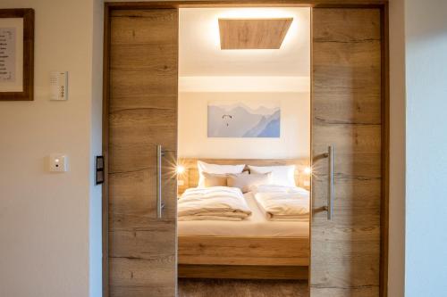 a sliding glass door leading into a bedroom with a bed at Haus am Rank in Oberstdorf