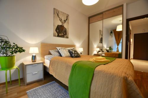 sypialnia z łóżkiem z zielonym kocem w obiekcie Młociny Metro Apartment w Warszawie