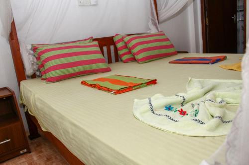a bed with two towels and pillows on it at Resort Deepika Mirissa in Mirissa