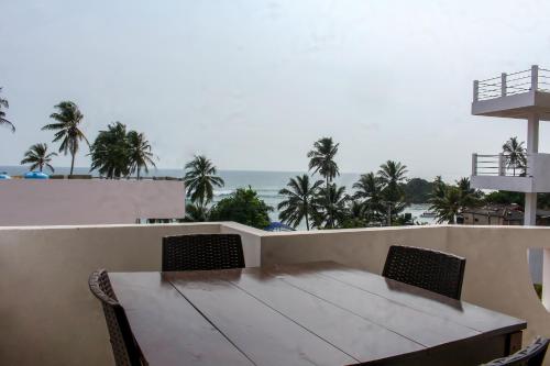 a dining room table with chairs and a balcony at Resort Deepika Mirissa in Mirissa