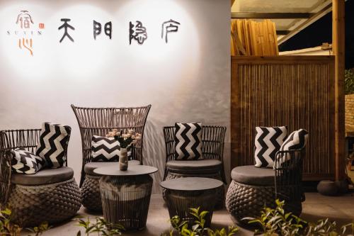 a group of chairs with pillows and a table at Zhangjiajie Su Xin Resort Near Tianmen Shan & Hehua airport-Free pick up in Zhangjiajie