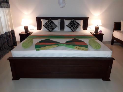 a bedroom with a bed with a bow tie on it at Sigiri Hibiscus Villa in Sigiriya