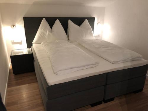 a large bed with white sheets and pillows at Haus Central Lofer in Lofer