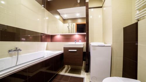 bagno con vasca, lavandino e servizi igienici di Apartments of Pawia a Cracovia