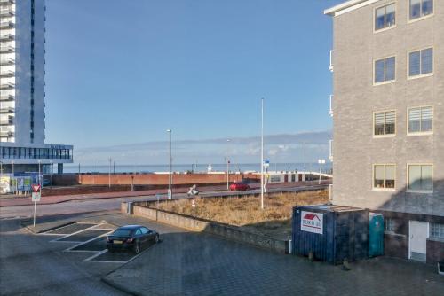 a car parked in a parking lot next to a building at Zeehuis Appartement & Studio in Zandvoort