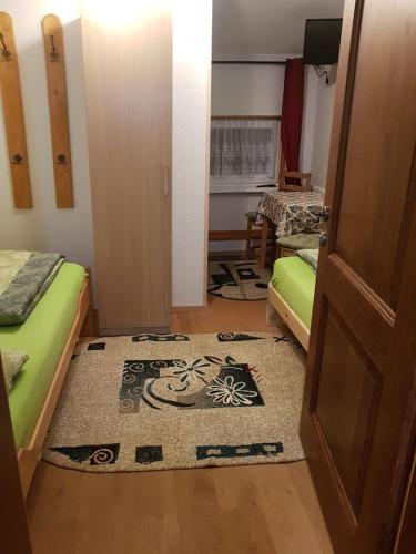 a room with two beds and a rug on the floor at Pension Haus Rohrmoser in Annaberg im Lammertal