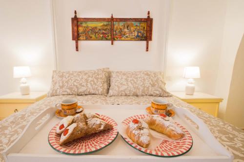 un vassoio con due piatti di cibo su un letto di I Mori Sicilian Apartment a Riposto