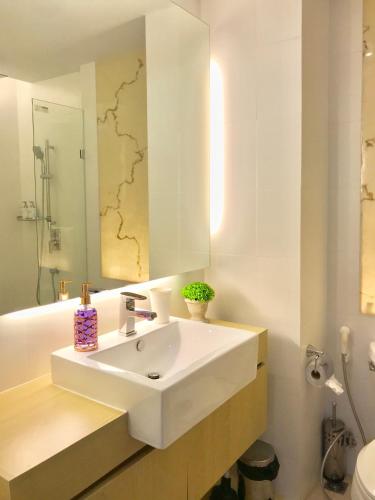 a bathroom with a white sink and a mirror at Atlantis Condo & Resort by Luxury Collection Apartment in Jomtien Beach
