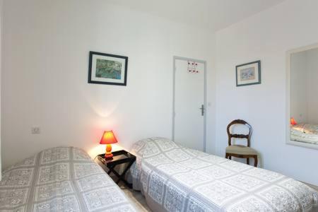 1 dormitorio con 2 camas y una lámpara en una mesa en La Bigotière avec clim et jardin, en Arles