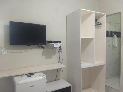 a bathroom with a tv on the wall above a toilet at Pousada Estrela Do Mar in Maragogi