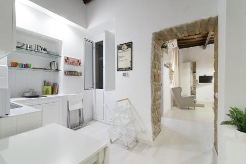 una cucina bianca con tavolo e sedia di White Ostilia Apartments a Roma