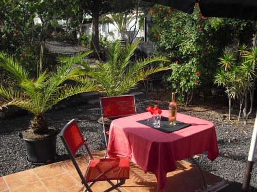 uma mesa com uma toalha de mesa vermelha e duas cadeiras vermelhas em Casa Sandra en Las Norias Todoque con Wi-Fi em Los Llanos de Aridane