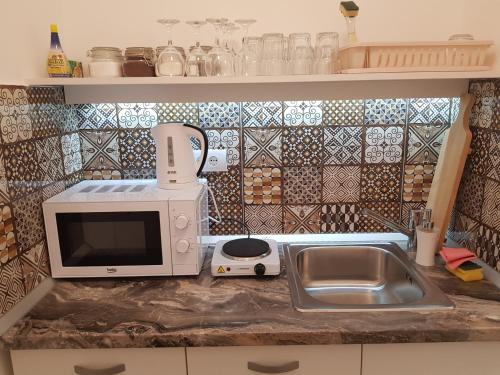 a kitchen counter with a microwave and a sink at Lux Apartment in Belgrade 2 in Belgrade